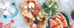 Festive Fourth of July picnic spread featuring a charcuterie board, fresh watermelon, berries, and colorful summer foods that inspire healthier holiday gatherings.