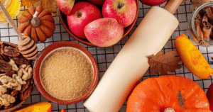 Autumn flat lay featuring fresh apples, pumpkin, seasonal squash, nuts, cinnamon, and honey, highlighting fall nutrition and immune health.