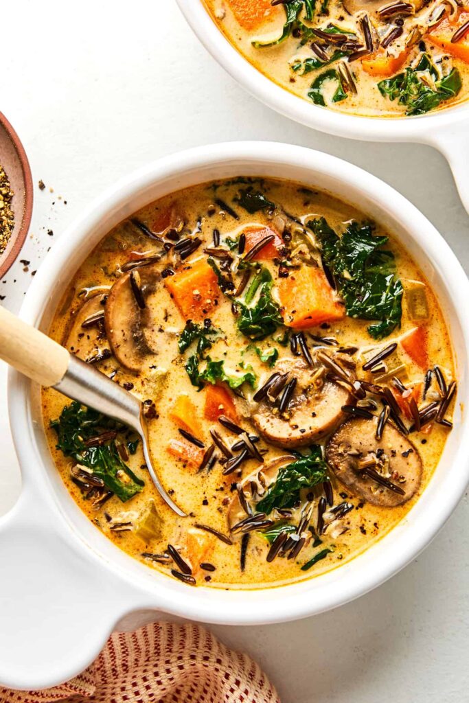Creamy autumn wild rice soup with sweet potatoes, mushrooms, kale and herbs for a cozy healthy fall meal.